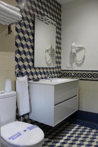 uma casa de banho com um WC, um lavatório e um espelho. em Alojamiento Rural La Estrella de David em Almagro