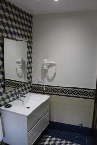 y baño con lavabo blanco y espejo. en Alojamiento Rural La Estrella de David en Almagro