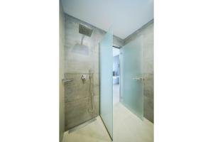 ein Bad mit einer Dusche und einer Glastür in der Unterkunft Thassos OLIVIA RESORT in Potos