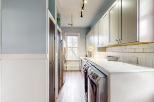a kitchen with white cabinets and white counter tops at The Charm of Wilmington in Wilmington