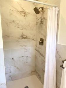 a bathroom with a marble shower with a shower curtain at Modern 1 Bedroom Apartment - 3 min walk to beach in Saint James