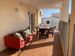 balcón con sofá, mesa y sillas en Waterside Apartment - Two Bedroom en Empuriabrava