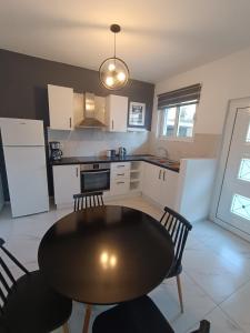 een keuken met een tafel en twee stoelen en een tafel en een keuken bij Alexander apartments in Spartia