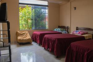 a room with three beds and a window at Residencial Tablada in Tarija