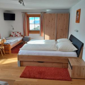 1 dormitorio con 2 camas y TV. en Schröckhof, en Stuhlfelden