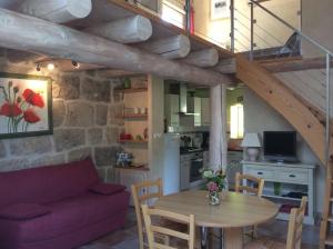 ein Wohnzimmer mit einem lila Sofa und einem Tisch in der Unterkunft Gîte de charme Le Havre de Paix d'Arcelet in Le Chambon-sur-Lignon