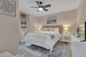 1 dormitorio blanco con 1 cama y ventilador de techo en Coastal 3BD Bungalow One Block from Scenic Walkway, en Oak Island