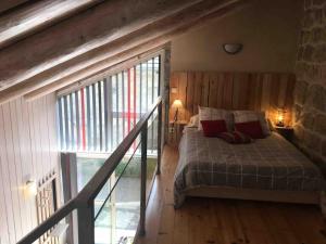 ein Schlafzimmer mit einem Bett in einem Zimmer mit einem Fenster in der Unterkunft Gîte de charme Le Havre de Paix d'Arcelet in Le Chambon-sur-Lignon