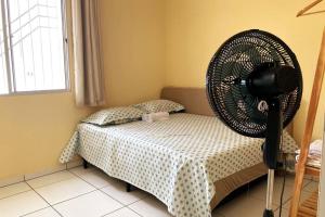 a bedroom with a fan on a bed at Casa Completa e Bem Localizada in Parnaíba