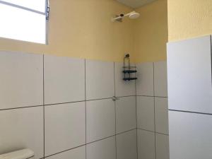 a bathroom with a shower with white walls and a window at Casa Completa e Bem Localizada in Parnaíba