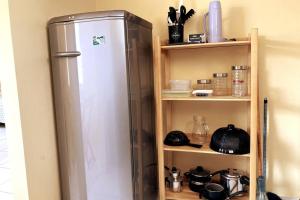 - un réfrigérateur installé dans une cuisine à côté d'une étagère dans l'établissement Casa Completa e Bem Localizada, à Parnaíba