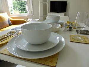 a white bowl on a plate on a table at Stylish studio apartment in central Hove. in Brighton & Hove