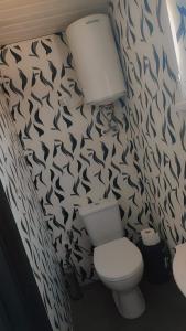 La salle de bains est pourvue de toilettes et d'un mur aux motifs de poisson. dans l'établissement Gravas mala, à Sigulda