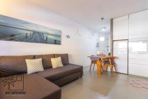 a living room with a couch and a table at Casa Design In the center by iRent Fuerteventura in Corralejo