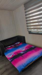 - une chambre avec un lit et une couverture colorée dans l'établissement Gravas mala, à Sigulda