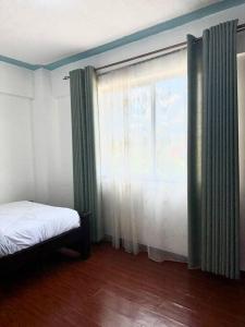 ein Schlafzimmer mit einem Bett und einem großen Fenster in der Unterkunft 2 Bedroom in Kilimani in Nairobi
