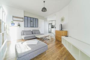 uma sala de estar com um sofá e uma mesa em Quiet cosy and large apartment with Terrace Top location em Saint-Ouen