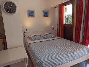 a bed in a room with a clock on the wall at Studio 4 pers, terrasse, clim, parking privé inclus in Cannes