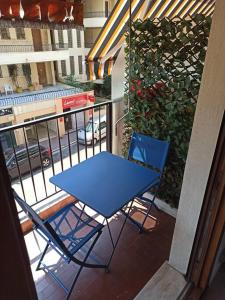 una mesa azul y sillas en el balcón en Studio 4 pers, terrasse, clim, parking privé inclus, en Cannes