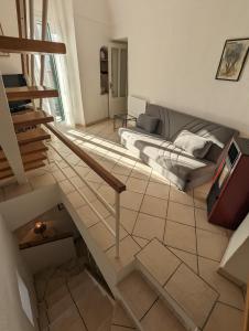sala de estar con escalera y sofá en La Casa degli Alberi, en Dolceacqua
