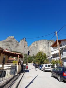 a street with a mountain in the background with cars parked at Antonioy Apartment Kalampaka in Kalabaka