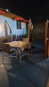 einen Tisch und Stühle in einem Zimmer mit einer Wand in der Unterkunft Casa Contêiner Luxo in Foz do Iguaçu