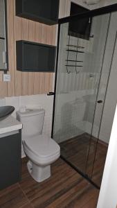 a bathroom with a toilet and a glass shower at Casa Contêiner Luxo in Foz do Iguaçu +20 photos