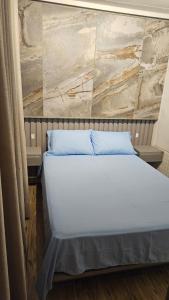 ein Schlafzimmer mit einem weißen Bett und einer Steinmauer in der Unterkunft Casa Contêiner Luxo in Foz do Iguaçu