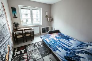 a bedroom with a bed and a table and a window at Apartamenty Bokserska in Warsaw +12 photos