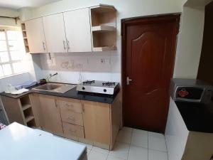 a small kitchen with a sink and a stove at Waridi Apartments in Nairobi