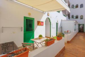 um pátio com uma porta verde e algumas plantas em Casa Design In the center by iRent Fuerteventura em Corralejo