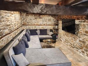 salon z kanapą i ceglaną ścianą w obiekcie Къща за гости Роден Балкан 