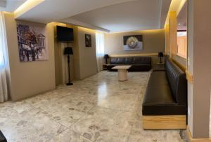 eine Lobby mit einem Sofa und einem Tisch in einem Zimmer in der Unterkunft Hotel Gran Vía in Mexiko-Stadt