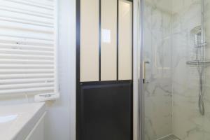 uma casa de banho com uma porta preta e um chuveiro em Quiet cosy and bright apartment with Terrace em Saint-Ouen