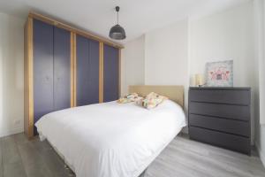 een slaapkamer met een groot wit bed en een dressoir bij Quiet cosy and bright apartment with Terrace in Saint-Ouen