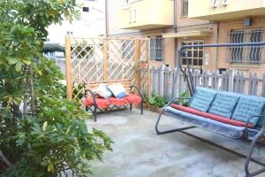 een patio met 2 stoelen en een schommel bij Appartamento MARISOL Grazioso e vicino al mare in Porto SantʼElpidio