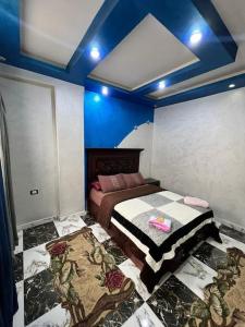 ein Schlafzimmer mit einem Bett in einem Zimmer mit blauen Decken in der Unterkunft Studio Jimmy in Kairo