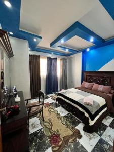 Schlafzimmer mit einem großen Bett und blauen Decken in der Unterkunft Studio Jimmy in Kairo