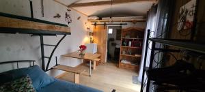een kamer met een stapelbed en een tafel in een kamer bij Les Milles Bottes et ses Roulottes in Encausse-les-Thermes