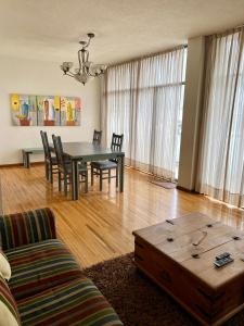 uma sala de estar com uma mesa e cadeiras e um sofá em Amplio departamento en la mejor zona de polanco em Cidade do México