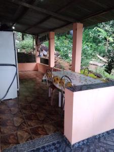 d'une terrasse avec une table, des chaises et un réfrigérateur. dans l'établissement Por do sol Jaguanum, à Mangaratiba