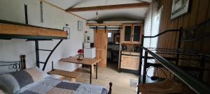 een kamer met een bed, een tafel en een trap bij Les Milles Bottes et ses Roulottes in Encausse-les-Thermes