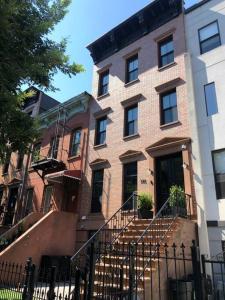 a brick building with stairs in front of it at Private Street Level Brownstone Apartment in Brooklyn