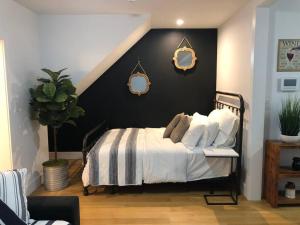 1 dormitorio con 1 cama con pared negra en Private Street Level Brownstone Apartment en Brooklyn