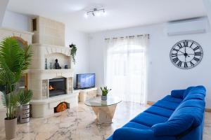 a living room with a blue couch and a clock at Villa in St Julian's with Private Pool in St Julian's