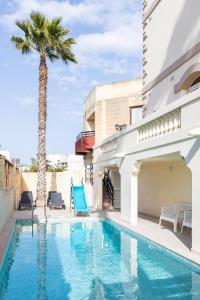 a villa with a palm tree and a swimming pool at Villa in St Julian's with Private Pool in St Julian's