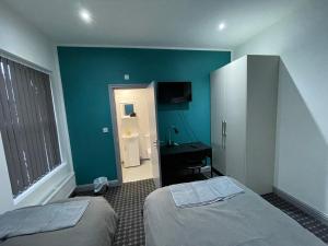 a room with two beds and a bathroom with a sink at Luxurious En-suite Room 4 in Manchester