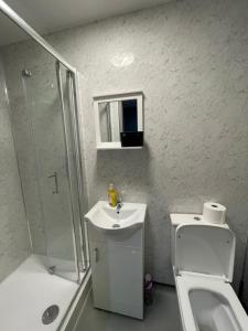 a bathroom with a sink and a toilet and a shower at Luxurious En-suite Room 4 in Manchester