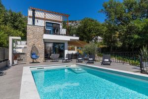 ein Swimmingpool vor einem Haus in der Unterkunft Vila Petram in Bribir