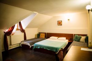 een slaapkamer met 2 bedden op een zolder bij Class in Petroşani